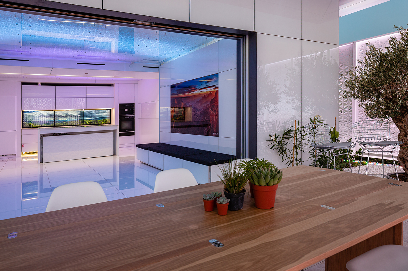FutureHAUS kitchen with a dining table, energy-efficient cooking countertop and high-adjustable cabinets.